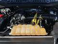 The image shows the engine compartment of a 2018 Ford F-150 featuring a yellow coolant reservoir and various engine components including hoses and a black air intake