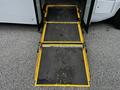 A yellow and black wheelchair ramp extending from the side of a 2019 Chevrolet Express van