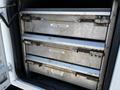 The image shows the open storage compartment of a 2004 Freightliner M2 featuring three metal drawers labeled for coffee and standard brackets, anchors, and exit brackets