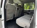 Interior back seating area of a 2020 Ford F-350 Super Duty featuring grey fabric seats and a fold-down console