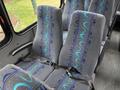 Interior seats of a 2020 Chevrolet Express with gray upholstery featuring a blue and teal wave pattern and seatbelts attached
