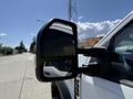 A 2023 Ford F-550 side mirror reflecting its surroundings