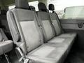 A row of three grey upholstered seats designed for a 2021 Ford Transit with seatbelts and a textured pattern on the seat backs