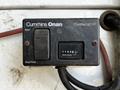 Control panel of a Cummins Onan generator showing a start switch and a total hours display at 1102.6 hours