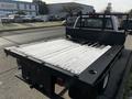 A 2017 Chevrolet Silverado 3500HD truck with a flatbed and a black metal railing on the back