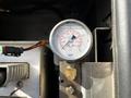 A pressure gauge displaying readings in psi and kPa mounted on metal equipment