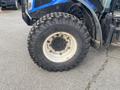 A close-up of a large, rugged tire from a 2016 New Holland T475 tractor showing a textured tread and rust on the rim