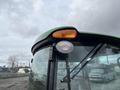 A 2014 John Deere 1585 Terrain Cut featuring a green and black color scheme with a prominent glass cab and an orange beacon light on top