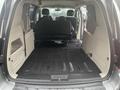 Interior view of a 2016 Dodge Grand Caravan showing the cargo space with rear seats folded down and black floor covering