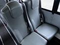 Two gray upholstered bus seats with seatbelts, arranged side by side in the interior of a vehicle