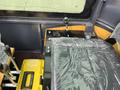 Interior view of a 2024 AGT Industrial Yellow H13R Mini Excavator showing the seat control levers and a tools box