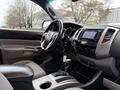 Interior of a 2015 Toyota Tacoma featuring a steering wheel dashboard and gear shift with a modern audio system and comfortable seating