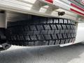 A 2016 Ford F-550 truck tire mounted under a trailer with a rugged tread design and metallic rim