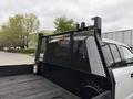 A 2020 Ford F-550 truck with a black mesh headboard and a flatbed design is shown in the foreground