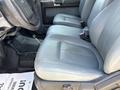 A close-up view of the front seats in a 2012 Ford F-450 SD featuring gray leather upholstery and a visible gear shift on the floor