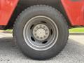 Close-up of a tire on a red 2013 Ford F-550 showing the tread and rim design