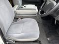 Interior view of a 2009 Toyota Hiace showing the driver's seat and grey fabric upholstery along with the steering wheel and center console