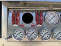 Control panel of a 2004 American LaFrance Eagle featuring foam level indicators and multiple pressure gauges