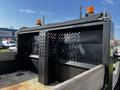 A 2021 Ford F-550 truck bed with metal side panels featuring a lattice design and mounted orange lights on top