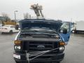 A 2009 Ford Econoline with its hood raised revealing the engine compartment and a crane attachment on top