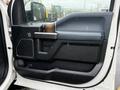 The interior door panel of a 2018 Ford F-150 featuring a black and brown design with storage compartments and a handle