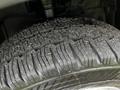 Close-up of a 2023 Ford Transit tire showing deep tread patterns and small debris on the surface
