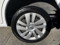 Close-up of a silver wheel with a Nissan logo on a 2017 Nissan NV200 with black tire tread visible