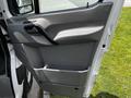 Interior door panel of a 2012 Mercedes-Benz Sprinter featuring a handle and a storage compartment