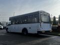 A white 2018 Chevrolet Express bus with large windows and a flat rear end parked on a concrete surface