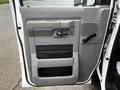 A gray door panel of a 2009 Ford Econoline featuring a handle and multiple storage compartments