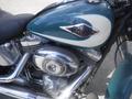 A 2009 Harley-Davidson FLSTC with a teal and cream tank and chrome engine parts prominently displayed