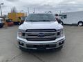 A white 2019 Ford F-150 with a chrome grille and a bold Ford emblem in the center facing forward