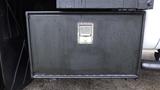 A black storage box mounted on the side of a 2011 Ford F-550 with a visible lock and water droplets on the surface