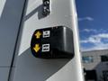 A black control panel with yellow arrows labeled "UP" and "DOWN" attached to a white surface