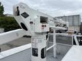 A Versalift aerial lift system mounted on a white 2018 Ford F-550 with controls and safety labels visible on the mast