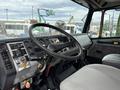 Interior view of a 1998 Freightliner FL80 with a steering wheel dashboard and controls visible including various gauges and a fan