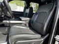 Interior view of a 2019 RAM 1500 featuring a black leather and mesh driver's seat with white stitching and a center console between the seats