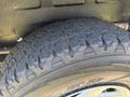 Close-up of a rugged tire from a 2008 Ford E-350 showcasing deep treads and wear patterns indicating its usage and durability