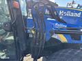 A blue New Holland T4050 tractor featuring hydraulic connections and a black cabin with visible controls and steering wheel