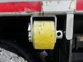 A yellow roller secured to a metallic frame on a Freightliner M2 106 truck showing wear and dirt on the surface
