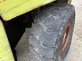 Close-up of a worn tire on a 2000 Clark GPS 15 forklift with a distinct tread pattern and red rim