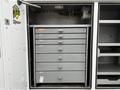 A 2017 Ford F-550 with a storage compartment featuring multiple gray drawers for organizing tools and equipment