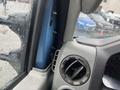 Close-up view of the interior of a 2009 Ford Econoline showing the dashboard air vent and part of the door panel with rain on the window glass