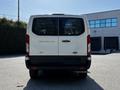 A white 2023 Ford Transit van with a rear view showing the model name and all-wheel drive label on the back door