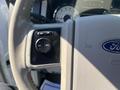 Close-up of the steering wheel controls of a 2013 Ford Expedition featuring buttons for cruise control settings and Ford branding