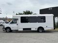 A white 2020 Chevrolet Express bus with large windows and a flat roof parked on a concrete surface