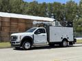 2023 Ford F-550 utility truck with a silver exterior featuring a ladder rack an enclosed work compartment and mounted equipment