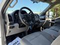 Interior view of a 2018 Ford F-150 showing the steering wheel dashboard and front seats with gray upholstery
