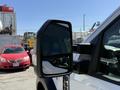 A white 2024 Ford F-550 Super Duty truck with a side mirror prominently displayed in the foreground