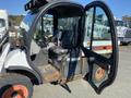 A 2015 Bobcat 5600 compact utility vehicle with an open door showing the driver's seat and controls inside the cabin